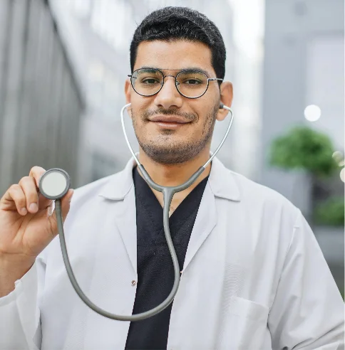 Ein freundlicher Arzt präsentiert sein Stethoskop mit einem Lächeln im Gesicht.